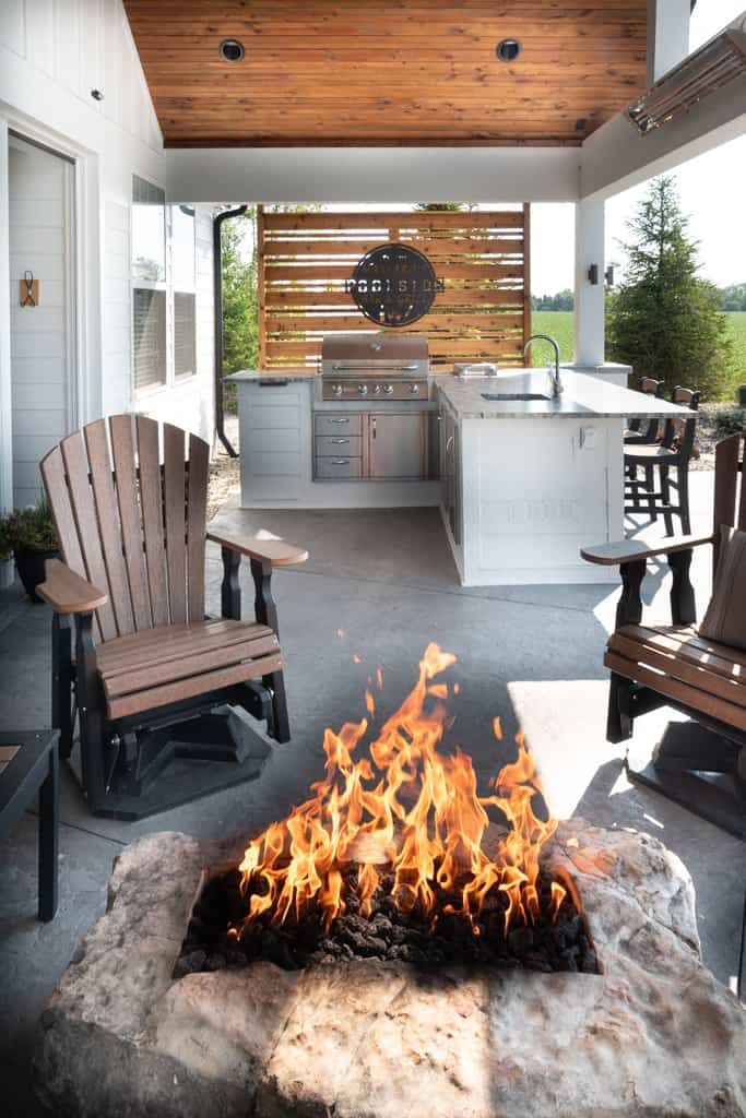 Nicholas Design Build | A remodel of an outdoor kitchen with a fire pit and chairs.
