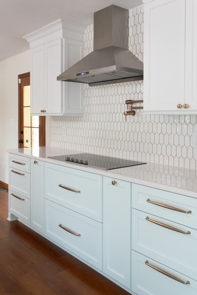 Nicholas Design Build | A remodeled kitchen with light blue cabinets and white counter tops.