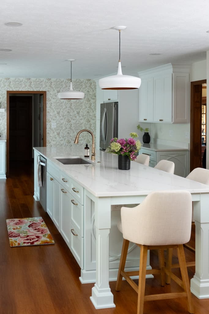 Nicholas Design Build |         A white kitchen with wooden floors and a center island ready for a remodel.
