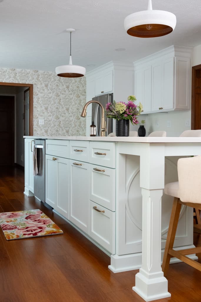 Nicholas Design Build | A white kitchen with wooden floors and a wooden island underwent a remodel.