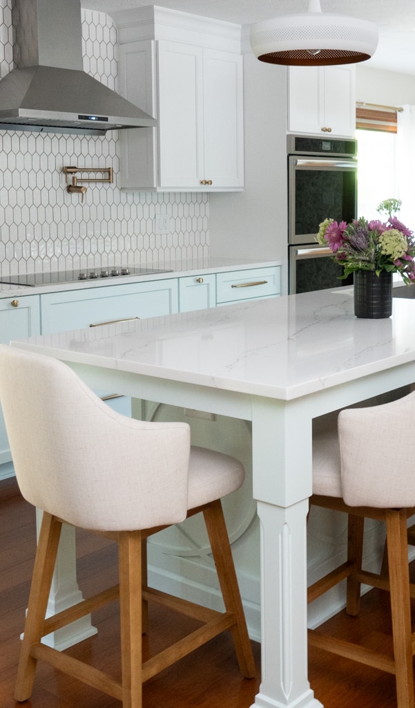Nicholas Design Build | A white island and chairs in a remodeled kitchen.