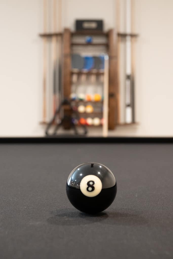 Nicholas Design Build | A black billiard ball on a remodeled billiard table.
