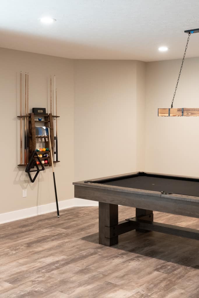 Nicholas Design Build | A remodeled basement with a pool table and hardwood floors.