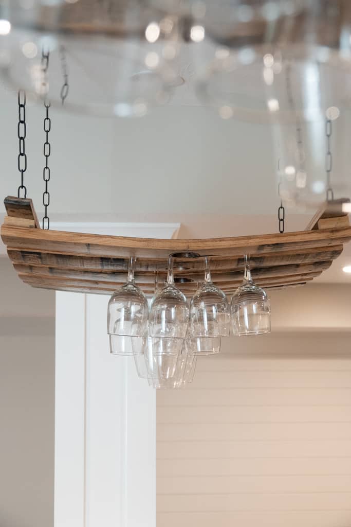 Nicholas Design Build | A remodelled wooden wine rack with wine glasses hanging from it.
