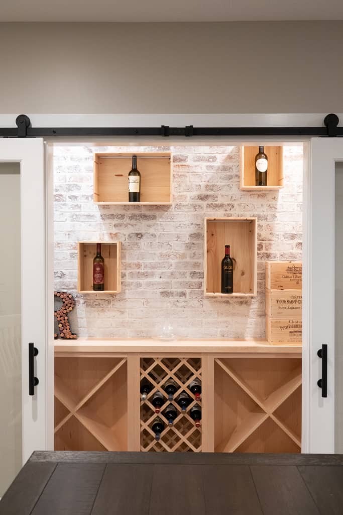 Nicholas Design Build | A remodeled wine cellar with a wooden door and shelves.