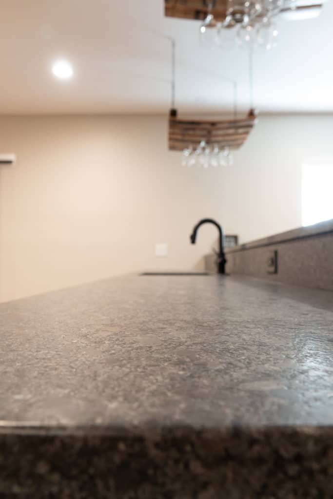 Nicholas Design Build | A remodeled kitchen counter with a sink and wine glasses.