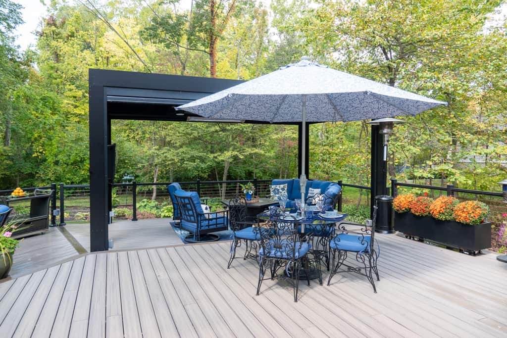 Nicholas Design Build | A blue umbrella on a wooden deck.