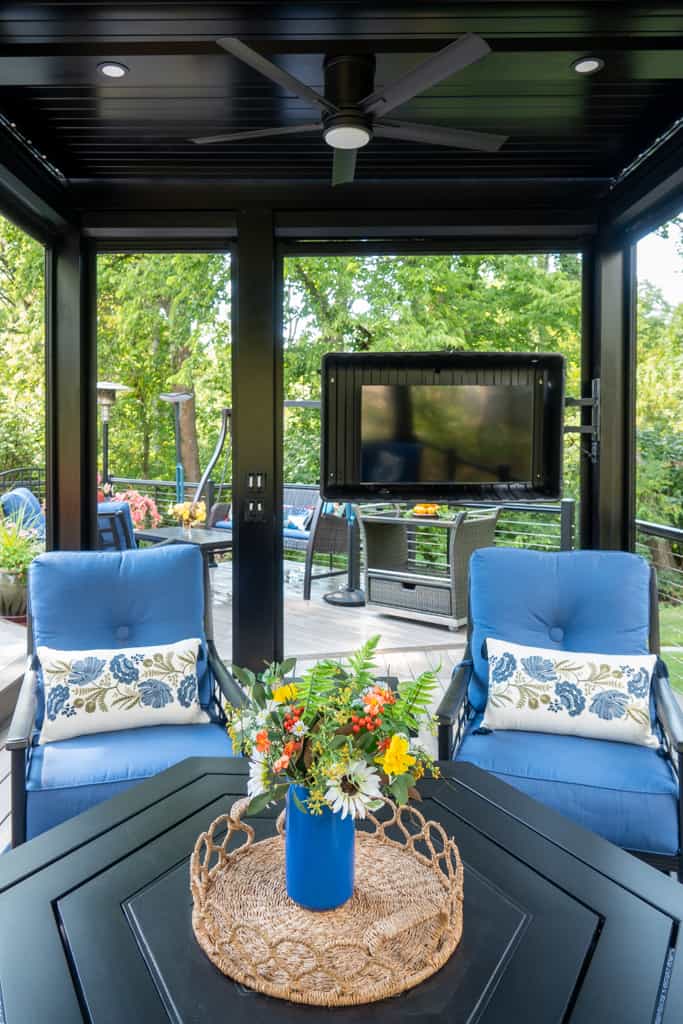Nicholas Design Build | A black gazebo with blue chairs and a tv.