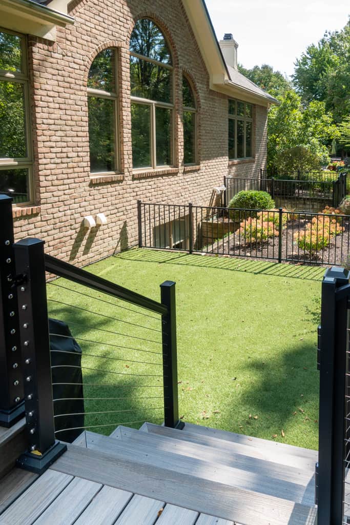 Nicholas Design Build | A deck with a black railing and a grassy area.