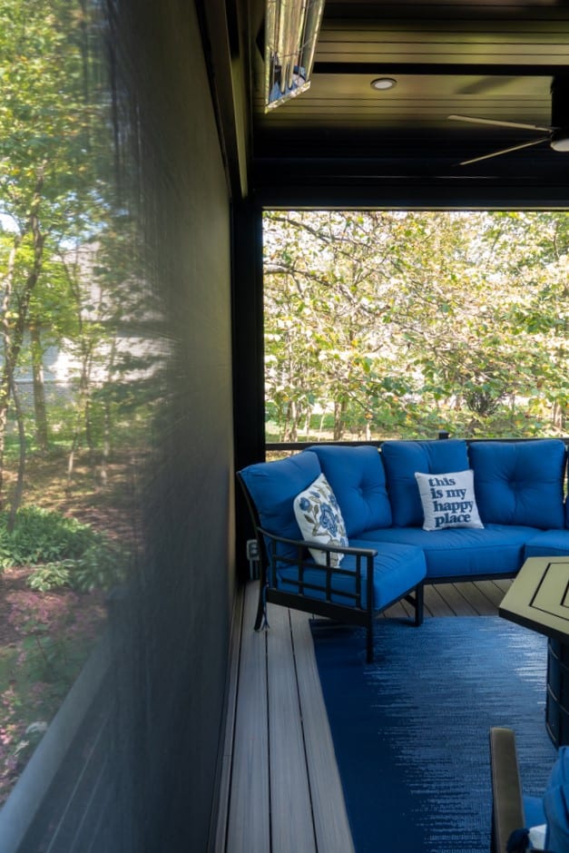 Nicholas Design Build | A patio with blue furniture and a fireplace.
