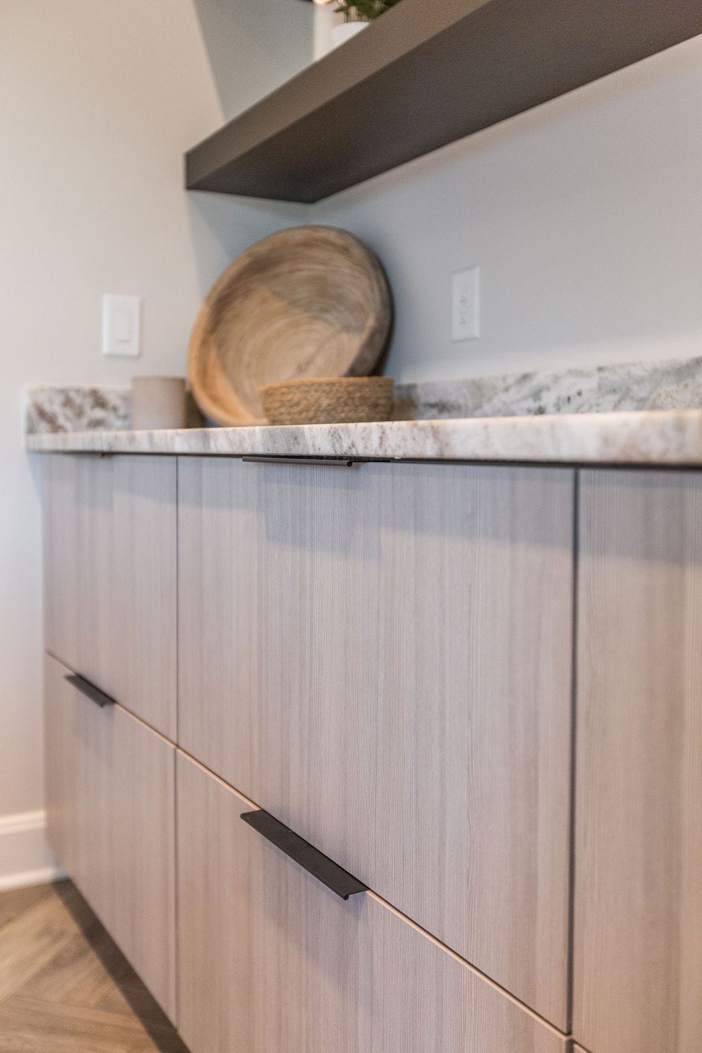 Nicholas Design Build | A kitchen with marble counter tops and wooden cabinets.