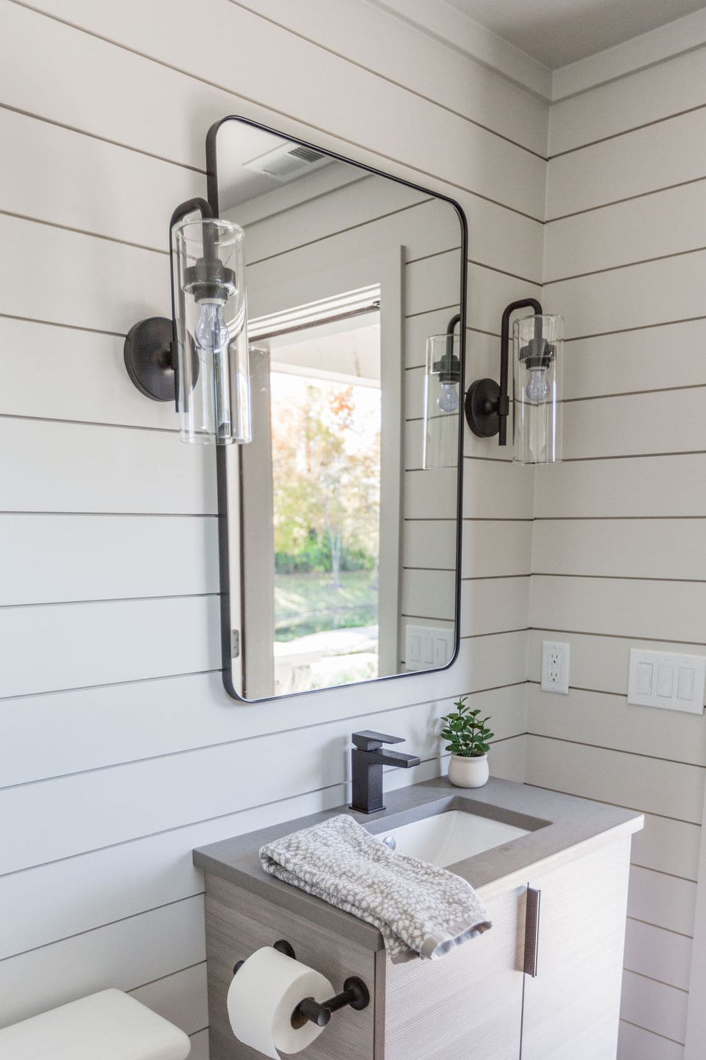 Nicholas Design Build | A bathroom with a mirror and a sink.