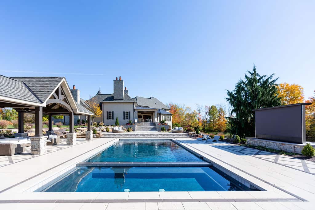 Nicholas Design Build | A swimming pool with a house in the background.
