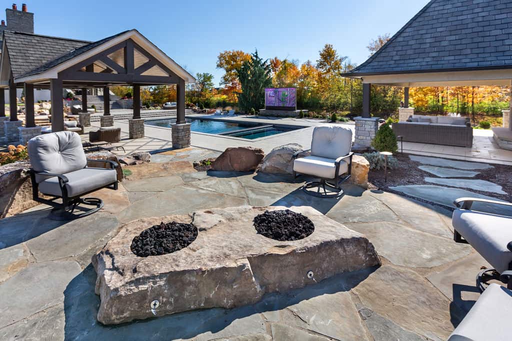 Nicholas Design Build | A patio with a pool and a chair.