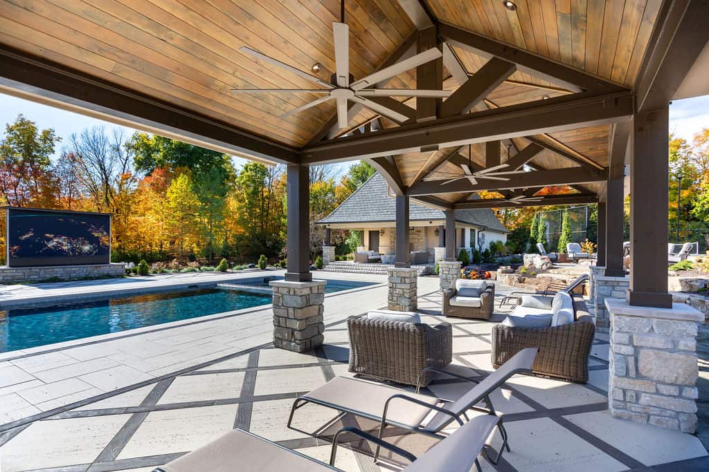Nicholas Design Build | An outdoor living area with a fireplace and a pool.