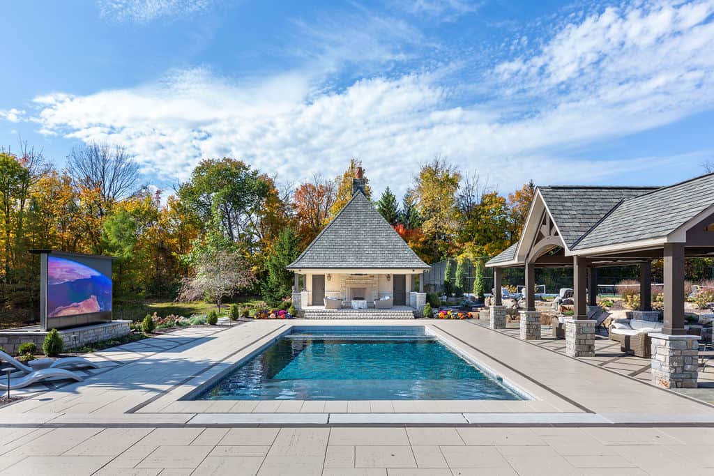Nicholas Design Build | A backyard with a pool and a large screen tv.