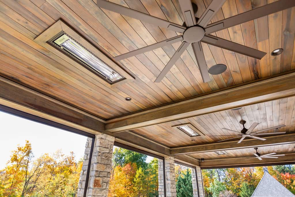 Nicholas Design Build | A covered patio with a ceiling fan and wood siding.