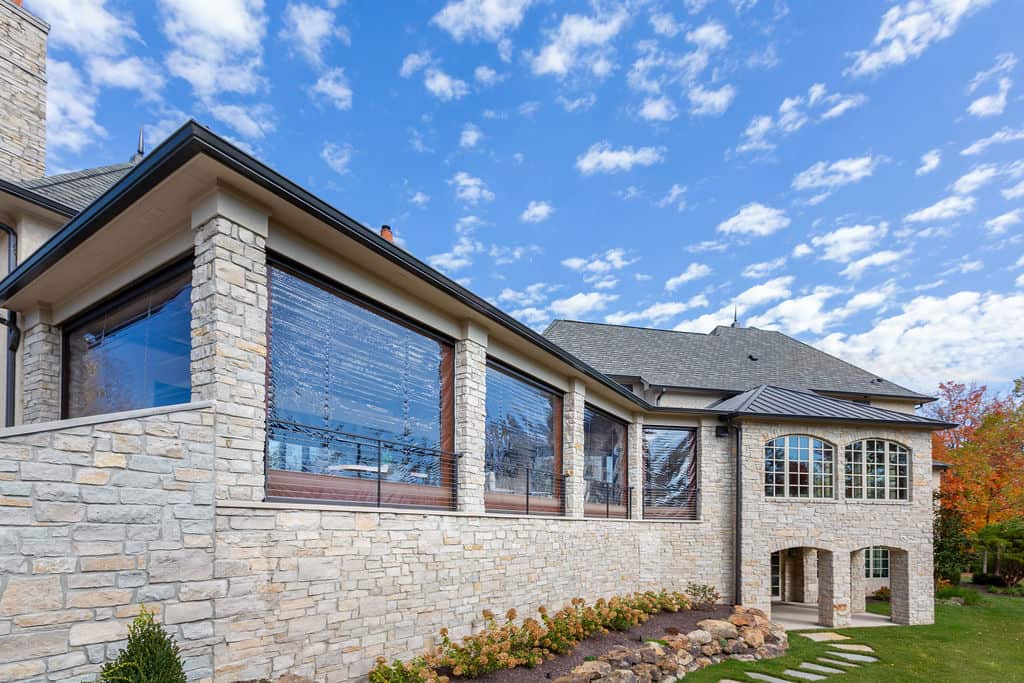 Nicholas Design Build | A large stone house with a stone patio.