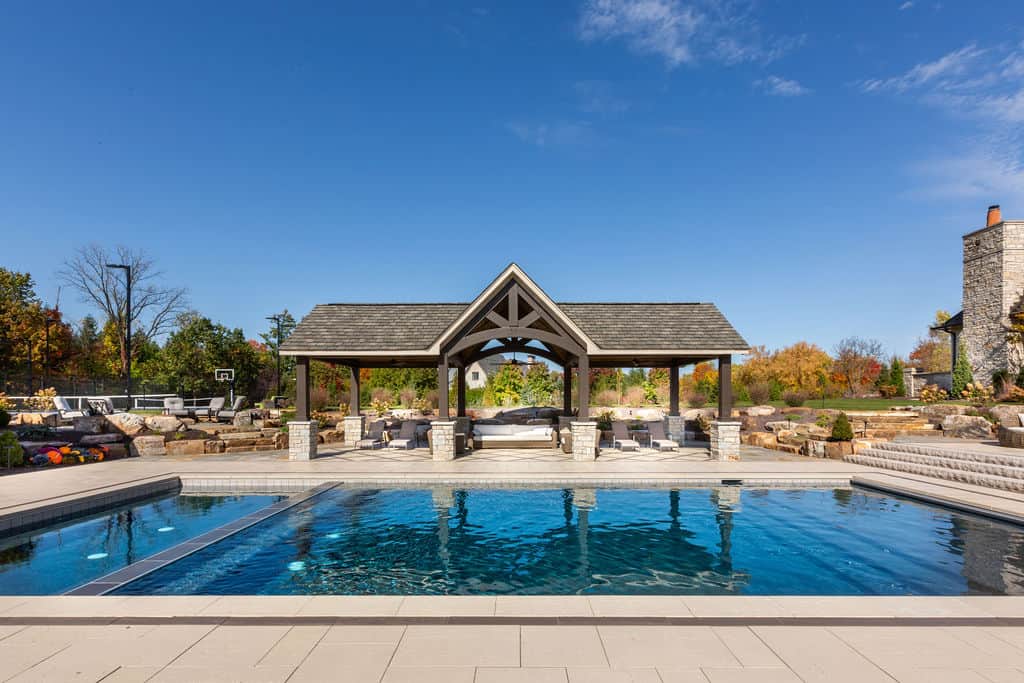 Nicholas Design Build | A swimming pool surrounded by a stone gazebo.