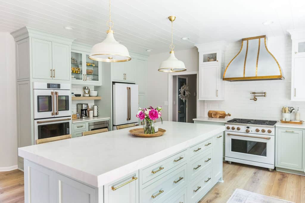 Nicholas Design Build | Bright, modern kitchen with white cabinetry, marble countertops, and pendant lighting.