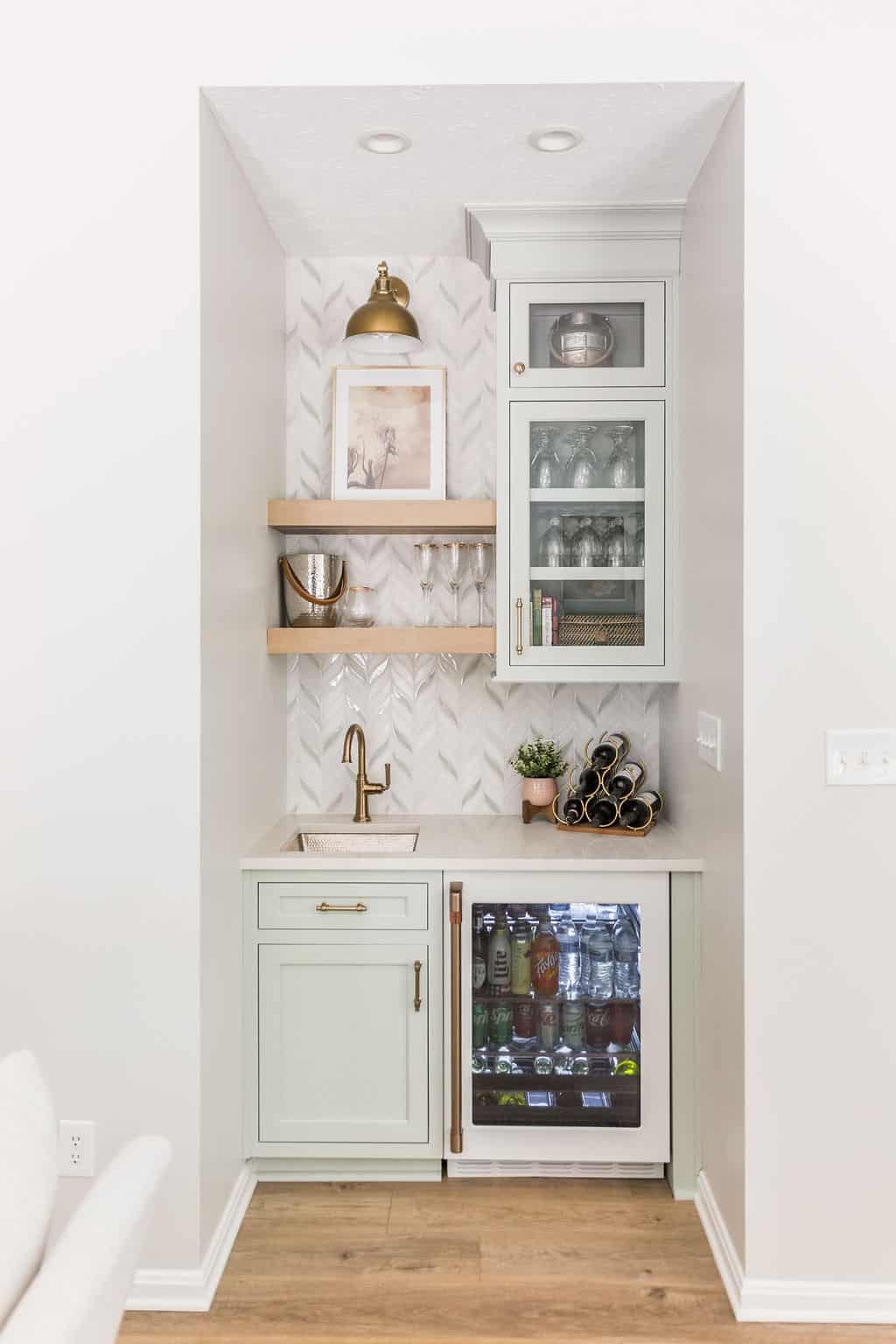 Nicholas Design Build | A modern kitchenette with herringbone tile backsplash, floating shelves, and a built-in beverage fridge.