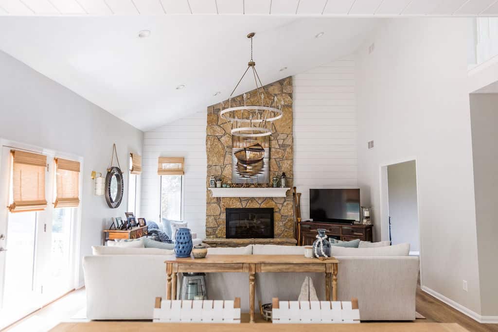 Nicholas Design Build | Bright and airy living room with a stone fireplace and vaulted ceiling.