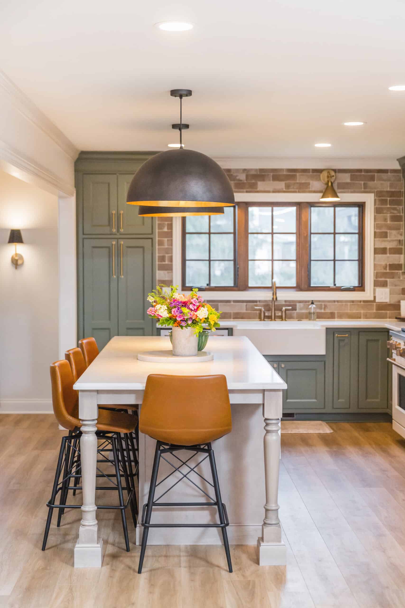 Nicholas Design Build | A bright, contemporary kitchen with a central island, bar stools, and pendant lighting.