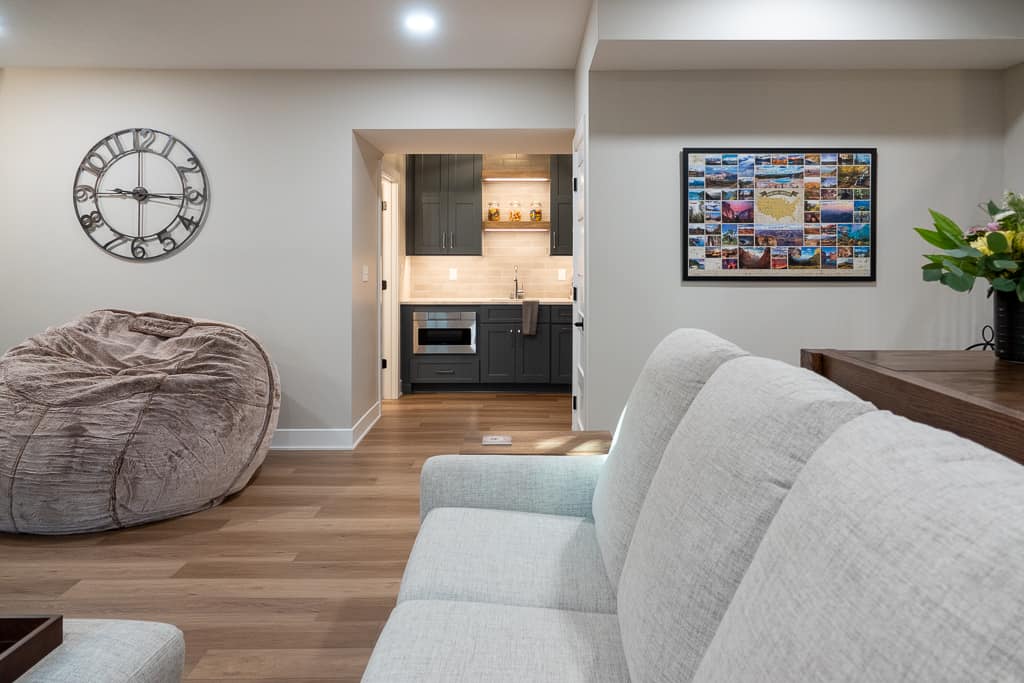 Nicholas Design Build | Modern living room with a view into a sleek, adjacent kitchen.