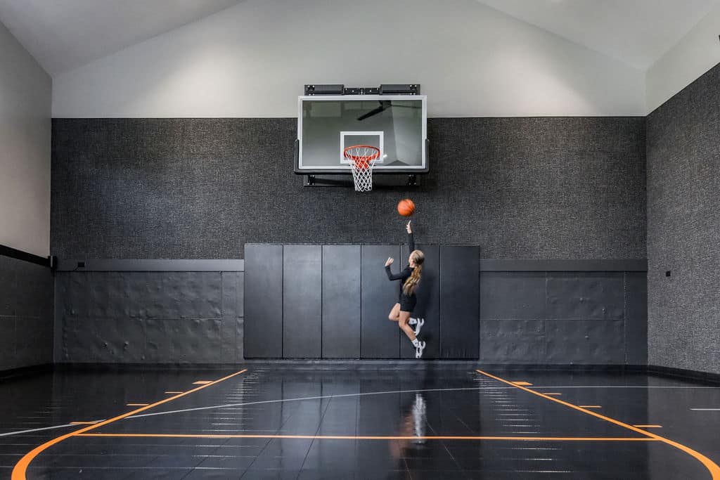 Nicholas Design Build | Person jumping to shoot a basketball in an indoor court.